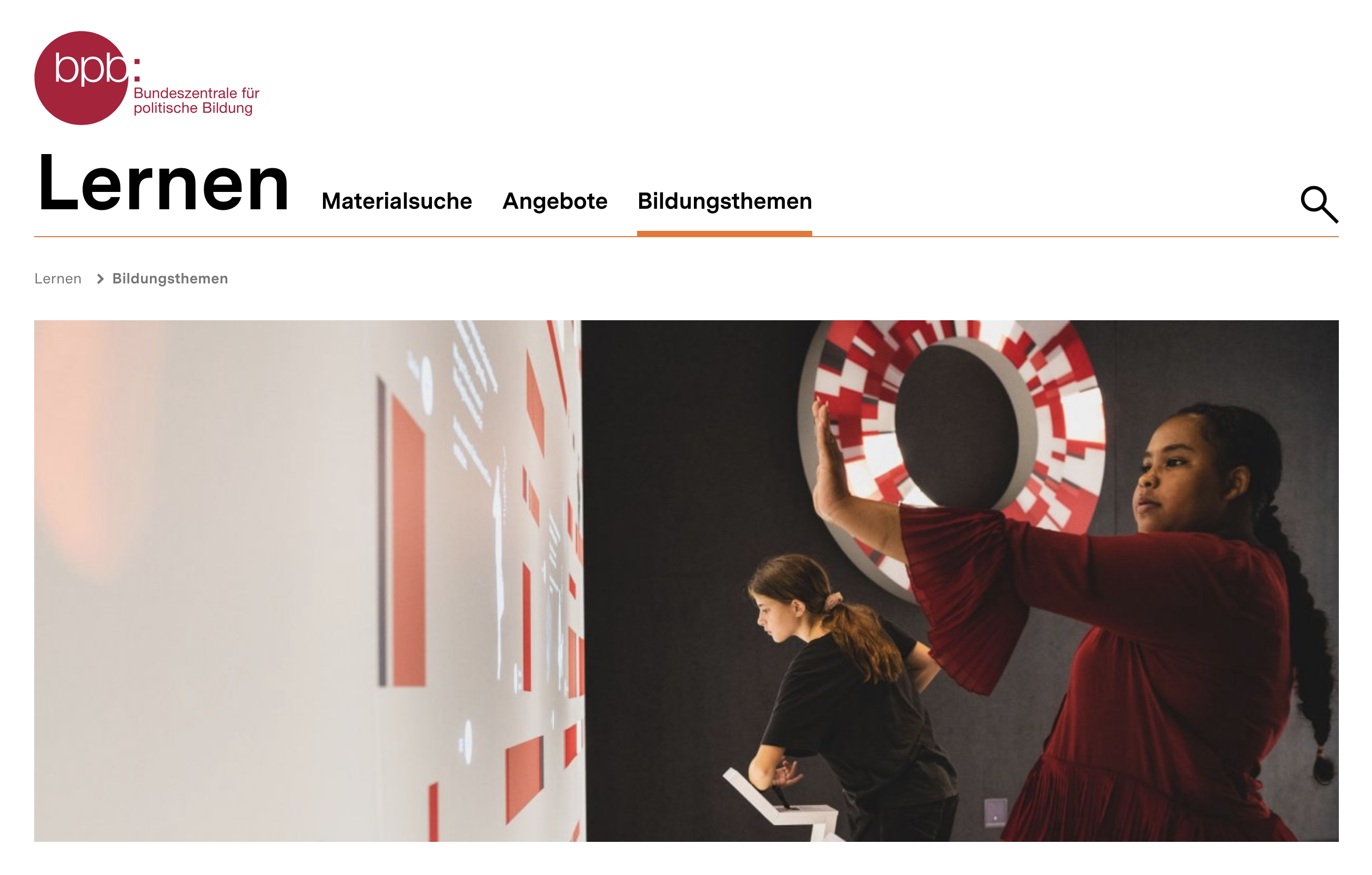 Screenshot der bpb-Lernseite „Bildungsthemen“ mit großem Foto von zwei Jugendlichen an einer interaktiven Ausstellung.