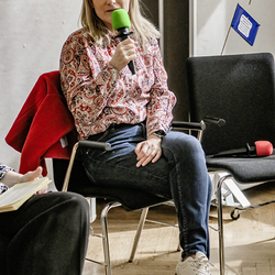 Elisabeth Grossmann spricht mit Mikrofon während einer Diskussionsrunde.
