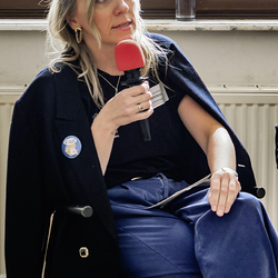 Aleksandra Wierzbicka spricht in einer Diskussionsrunde mit einem roten Mikrofon in der Hand.