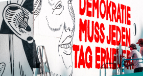Banner ein stilisierter Frauenkopf und daneben der Text: Demokratie mu jeden Tag erneuert werden